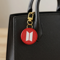 Llavero circular rojo sobre una cartera negra